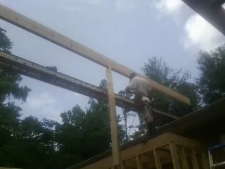 Carpenter setting a ridge beam over a new addition frame — Ice Dam Removal by Roofing Brothers in East Lansing