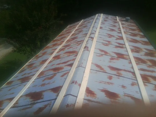 Rusted metal roof panels with new wood purlins before replacement — Storm Damage Roof Repair in East Lansing by Roofing Brothers
