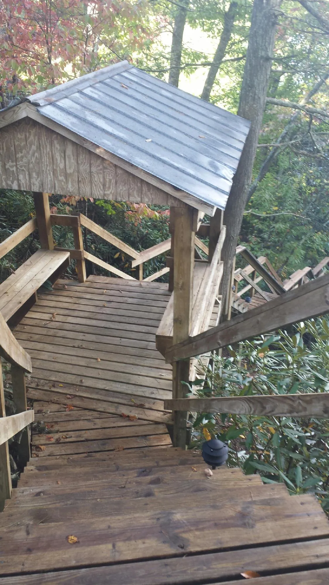 Metal roofed shelter over wooden steps on a wooded walkway — Skylight Repair & Installation work by our crew in East Lansing