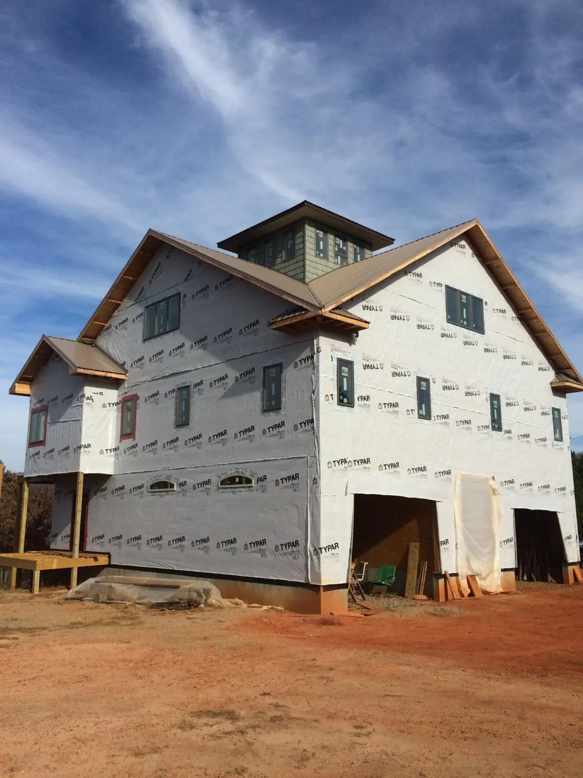 New two story house under construction with a cupola and gabled roofs in East Lansing